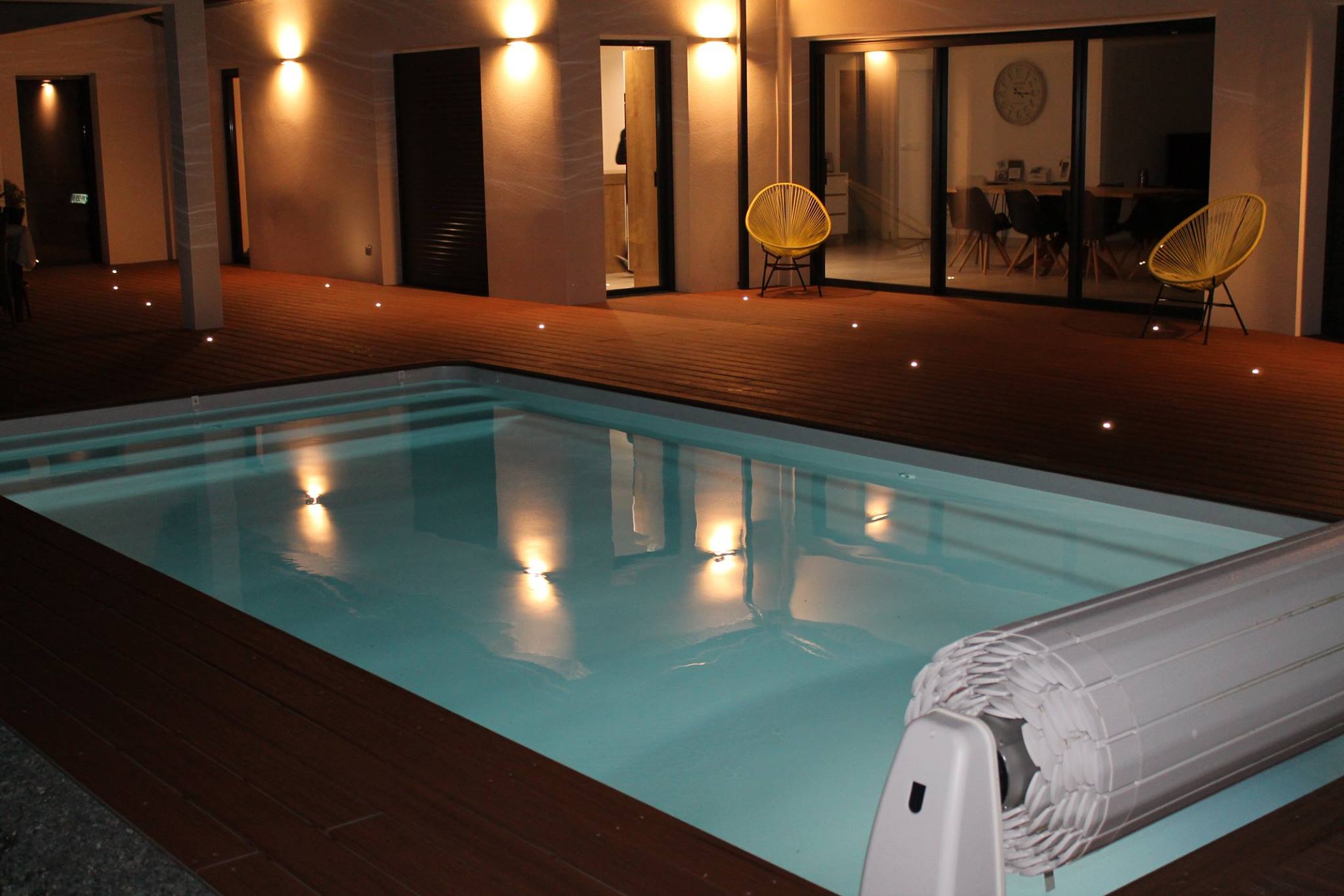 Piscine installée avec un volet hors sol, de nuit, avec des éclairages tamisés - Piscines Excellence